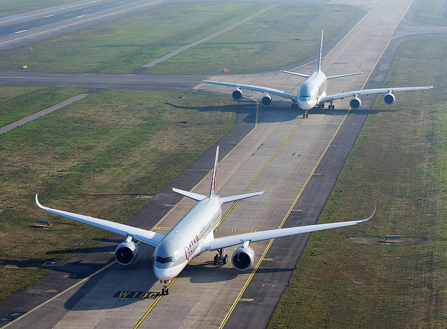 A Qatar Airways vadonatúj A350 repülőgépe és mögötte az A380-as felszállásra kész a toulousi Airbus gyár futópályáján.